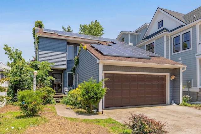 129 W Hollywood Ave, Wildwood Crest, NJ 08260 - view of front of house featuring solar panels, an attached garage, concrete driveway, and a shingled roof