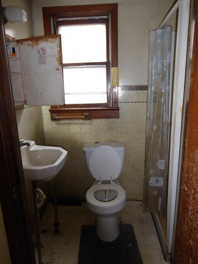 bathroom featuring toilet, tile walls, sink, and a shower with shower curtain