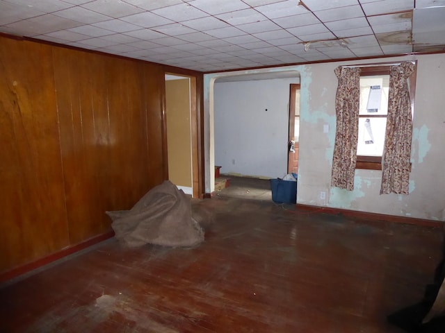 unfurnished room featuring wooden walls