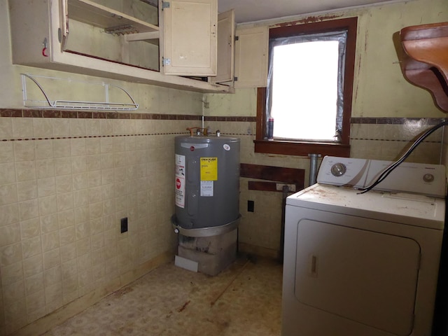 clothes washing area with washer / dryer, cabinets, tile walls, and electric water heater