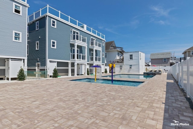 view of swimming pool with pool water feature and a patio area