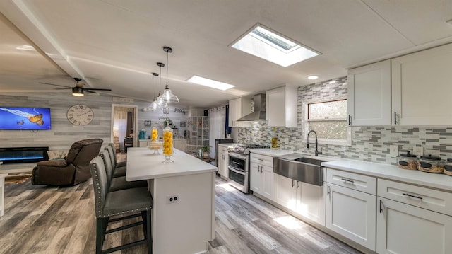 38 Kings Ln, Cape May Court House, NJ 08210 - kitchen featuring double oven range, wall chimney exhaust hood, open floor plan, light wood-type flooring, and a glass covered fireplace