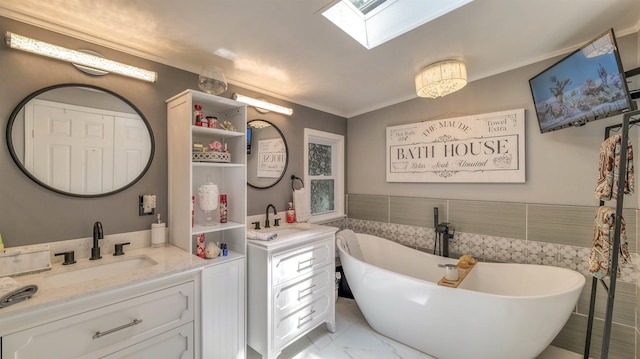 38 Kings Ln, Cape May Court House, NJ 08210 - bathroom with two vanities, ornamental molding, a skylight, marble look tiles, and a freestanding tub