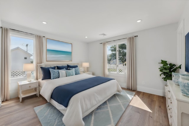 bedroom featuring multiple windows and light hardwood / wood-style floors