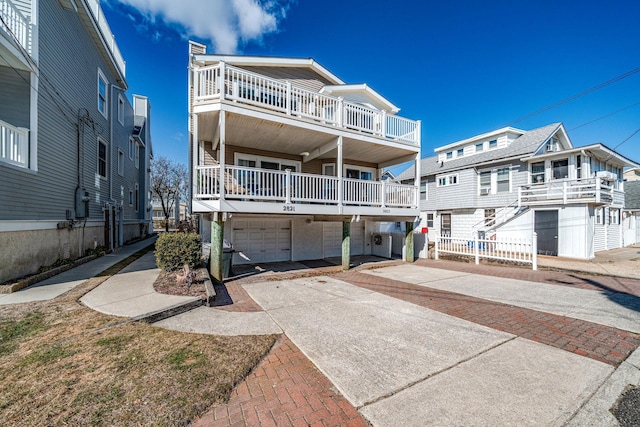 raised beach house featuring an attached garage and driveway