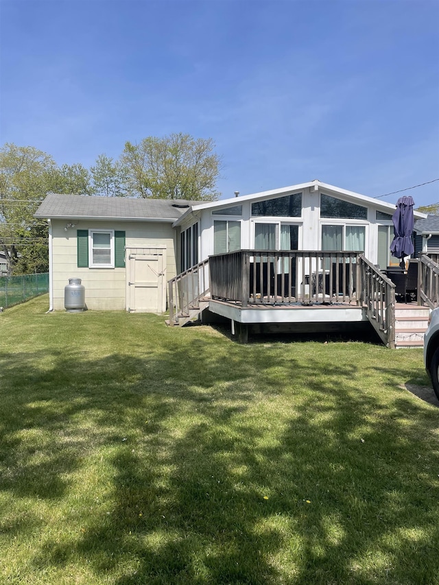 back of house featuring a yard and a wooden deck