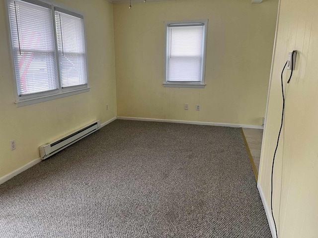 unfurnished room with dark colored carpet and baseboard heating