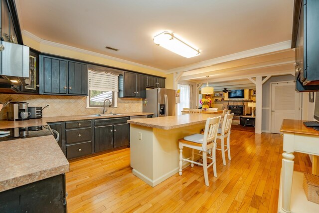 5 Edwards Ter, Seaville, NJ 08230 - kitchen with stainless steel fridge, crown molding, a fireplace, a breakfast bar area, and a sink