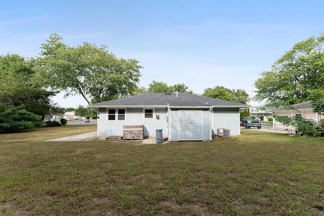 back of property with a lawn and central AC unit