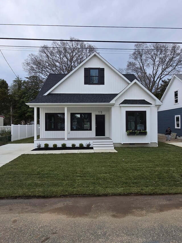 modern farmhouse style home featuring a porch and a front lawn