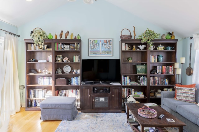 living area featuring vaulted ceiling and wood finished floors