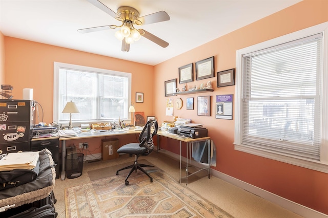 carpeted home office featuring ceiling fan and baseboards