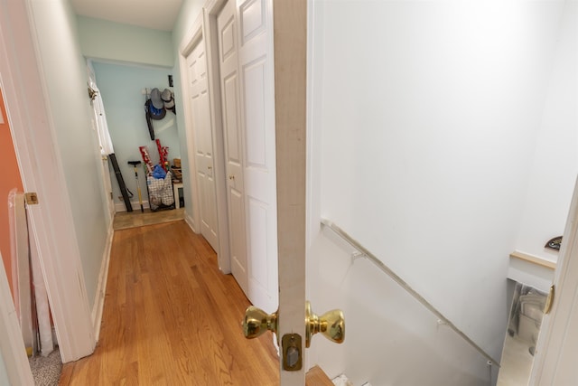 corridor with light wood-style flooring and baseboards