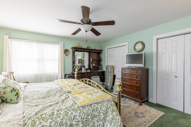 carpeted bedroom with ceiling fan and multiple closets