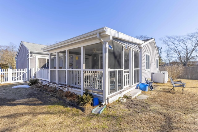 view of home's exterior with fence and a sunroom