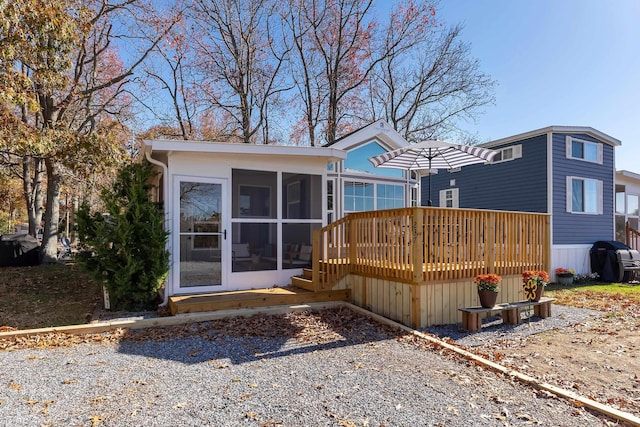 rear view of property with a deck and a sunroom