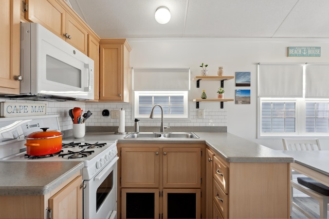 kitchen featuring white appliances, a sink, light countertops, light brown cabinets, and backsplash