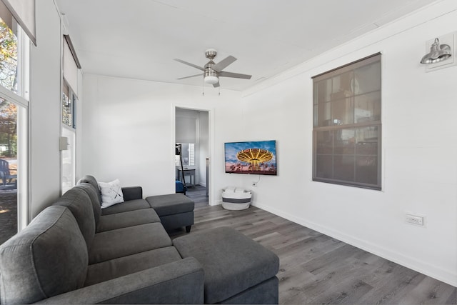 living area with a ceiling fan, baseboards, and wood finished floors