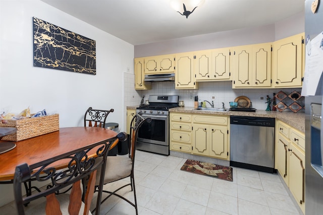 222 E 2nd Ave, North Wildwood, NJ 08260 - kitchen with appliances with stainless steel finishes, under cabinet range hood, decorative backsplash, cream cabinetry, and light tile patterned floors