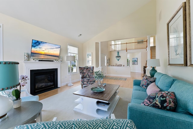 living room with light hardwood / wood-style floors and high vaulted ceiling