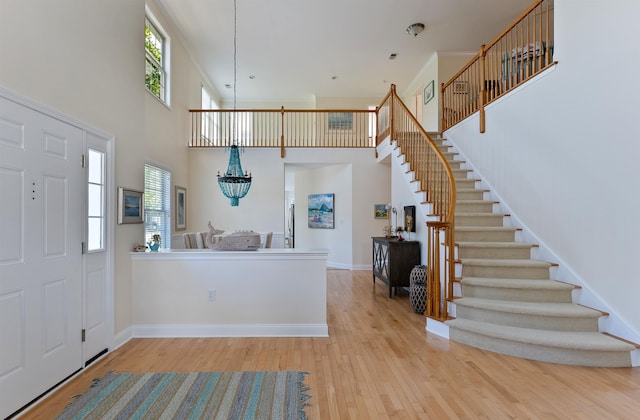 foyer featuring a high ceiling, light hardwood / wood-style floors, and a wealth of natural light