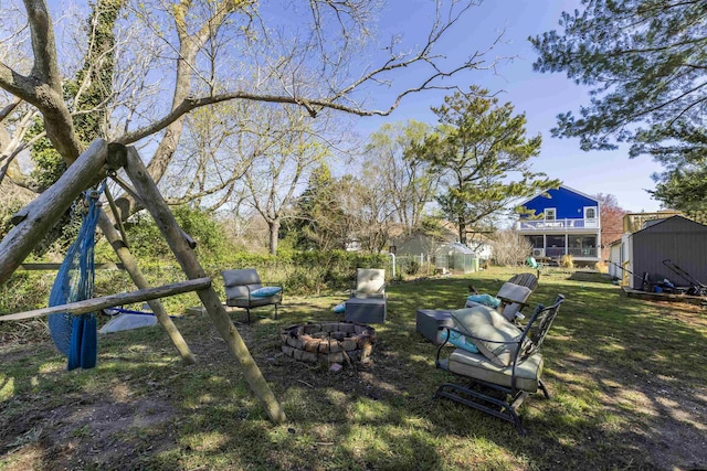 151 Stimpson Ln, West Cape May, NJ 08204 - view of green lawn featuring a fire pit, a storage shed, an outbuilding, and a wooden deck