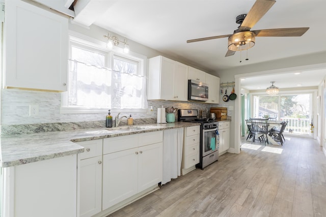 151 Stimpson Ln, West Cape May, NJ 08204 - kitchen with appliances with stainless steel finishes, white cabinets, backsplash, ceiling fan, and light wood finished floors