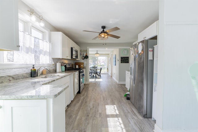 151 Stimpson Ln, West Cape May, NJ 08204 - kitchen featuring stainless steel appliances, a sink, a ceiling fan, white cabinets, and light stone counters