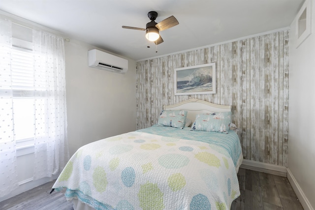 151 Stimpson Ln, West Cape May, NJ 08204 - bedroom featuring a wall mounted air conditioner, an accent wall, wood finished floors, baseboards, and ceiling fan