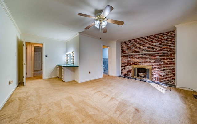 unfurnished living room with ceiling fan, light colored carpet, a fireplace, baseboards, and ornamental molding