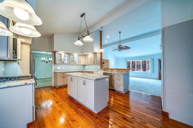 kitchen with vaulted ceiling with beams, a peninsula, a kitchen island, decorative backsplash, and glass insert cabinets