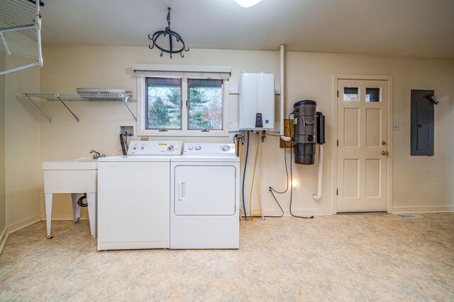 laundry room featuring laundry area, electric panel, baseboards, washer and clothes dryer, and tankless water heater