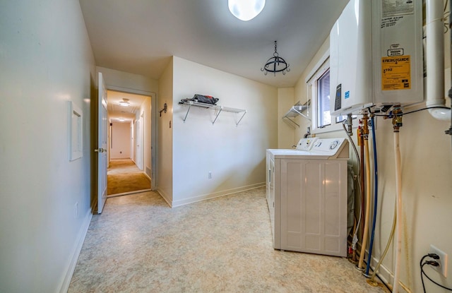 laundry room featuring tankless water heater, laundry area, baseboards, and washer and clothes dryer