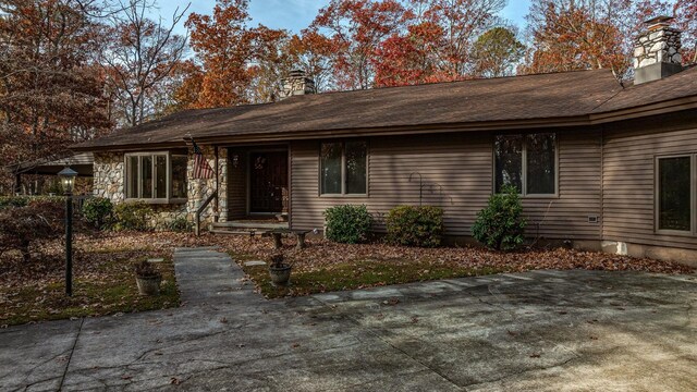 view of front of property with stone siding and a chimney