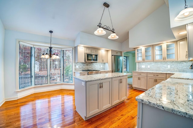 kitchen with stainless steel appliances, decorative light fixtures, and a kitchen island