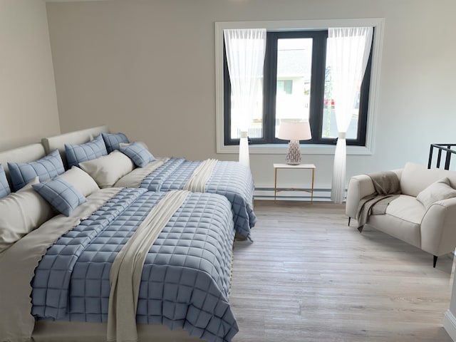 bedroom with baseboard heating and wood finished floors