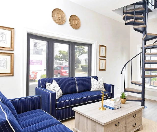 living room with baseboards, stairway, and light wood finished floors