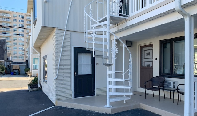 entrance to property with brick siding and a porch