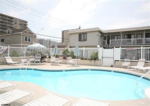 pool with a patio and fence