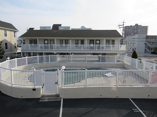 view of building exterior with fence and a community pool