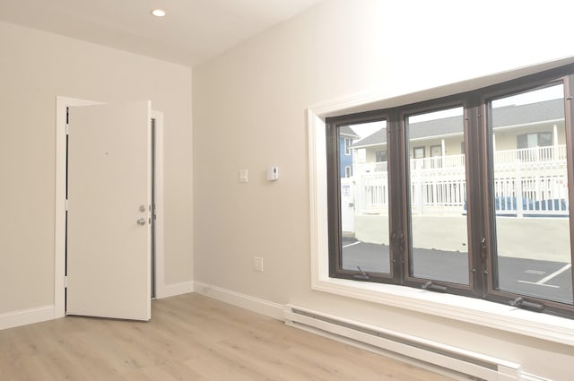 spare room with light wood-type flooring, baseboards, a baseboard heating unit, and recessed lighting