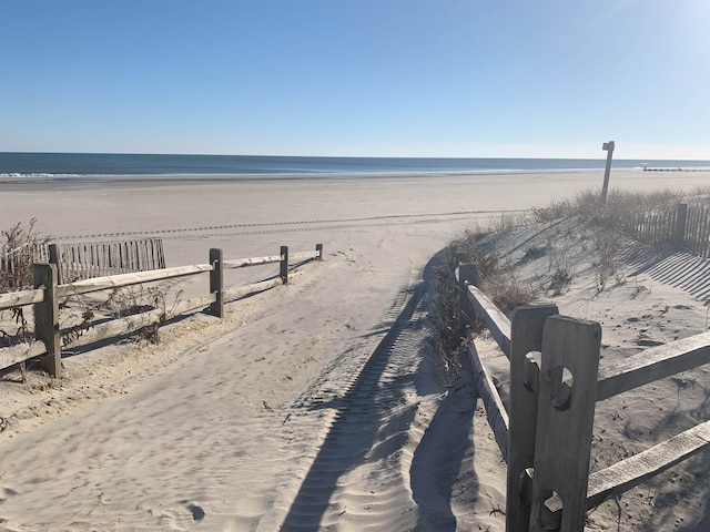 water view with fence and a view of the beach