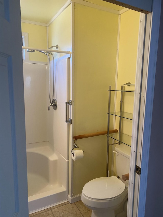 bathroom featuring toilet, a shower, and tile patterned floors