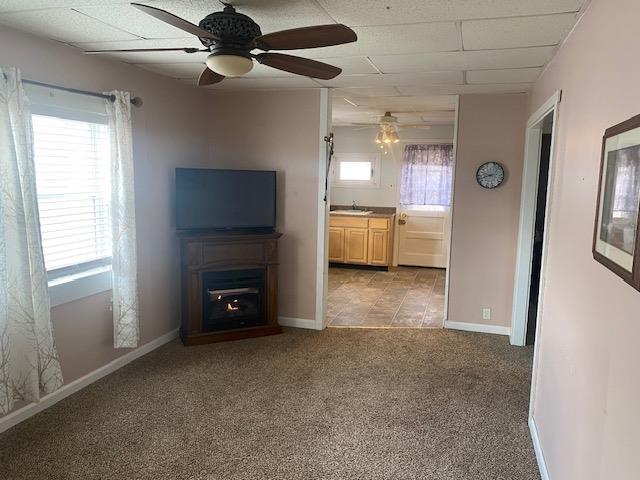 unfurnished living room featuring light colored carpet and ceiling fan