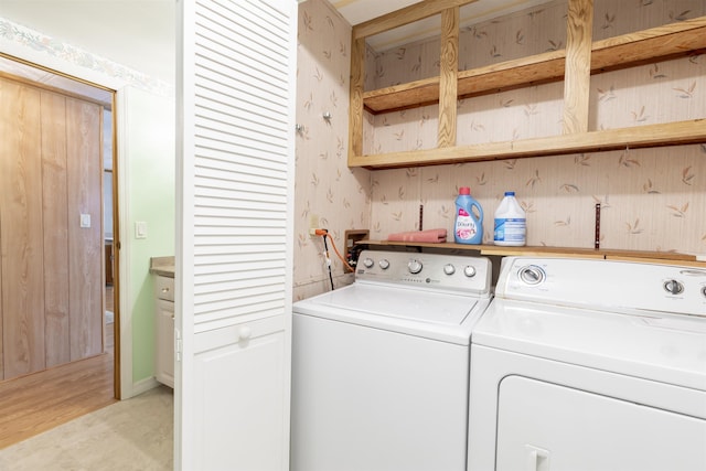 clothes washing area featuring independent washer and dryer, laundry area, wallpapered walls, and light wood-type flooring