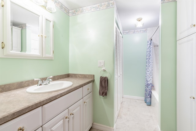 full bath featuring baseboards, shower / tub combo with curtain, and vanity