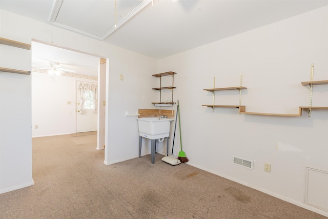 spare room featuring carpet flooring, ceiling fan, attic access, baseboards, and visible vents