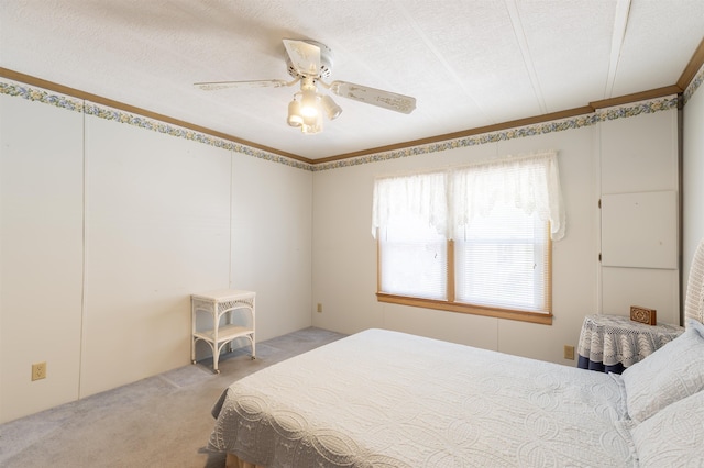 bedroom with a textured ceiling, light colored carpet, and ceiling fan