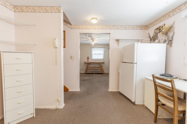 kitchen featuring baseboards, ceiling fan, freestanding refrigerator, and light carpet