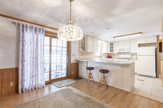 kitchen with light wood-style floors, a wealth of natural light, and white appliances